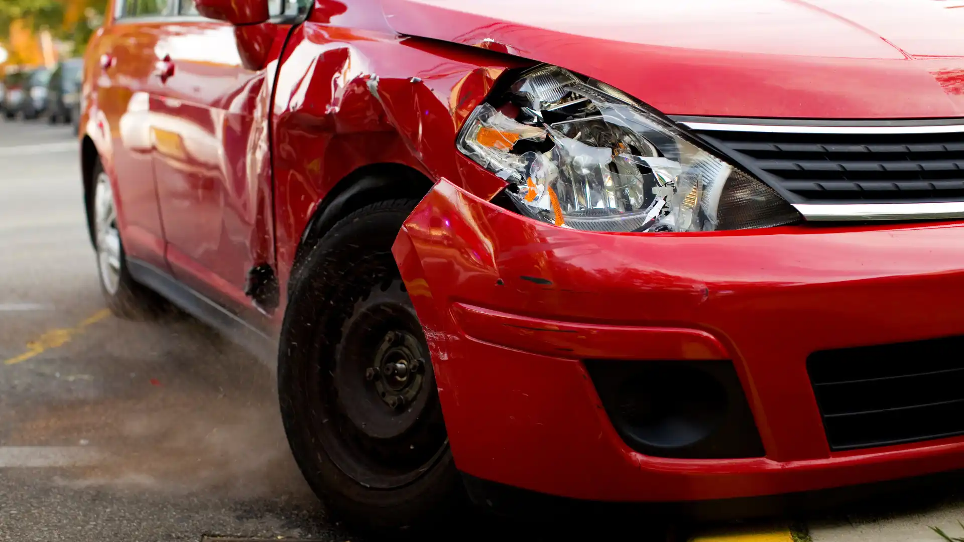 A red car with severe front-end damage after an accident.