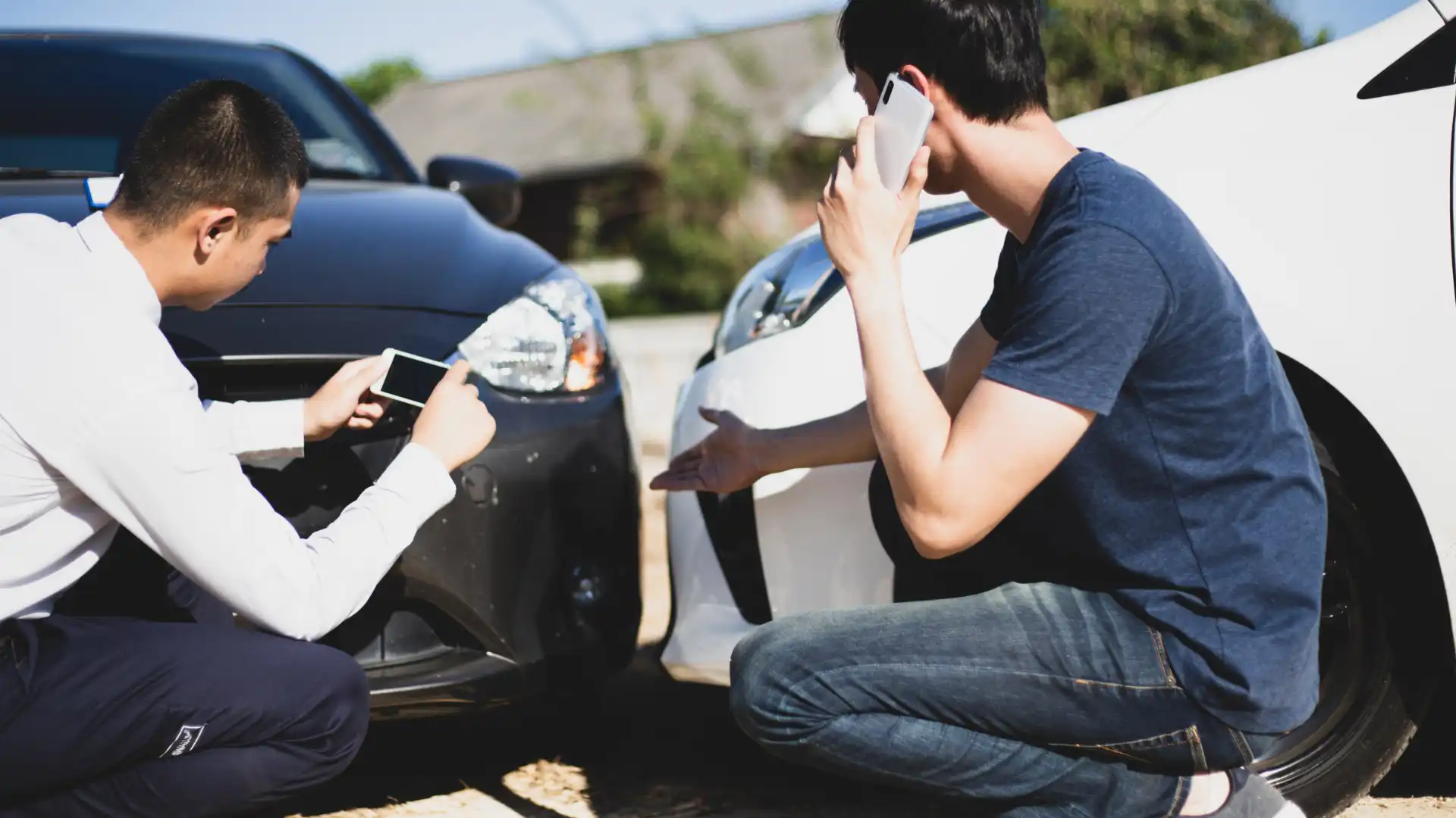 Two people documenting and discussing a minor car accident.