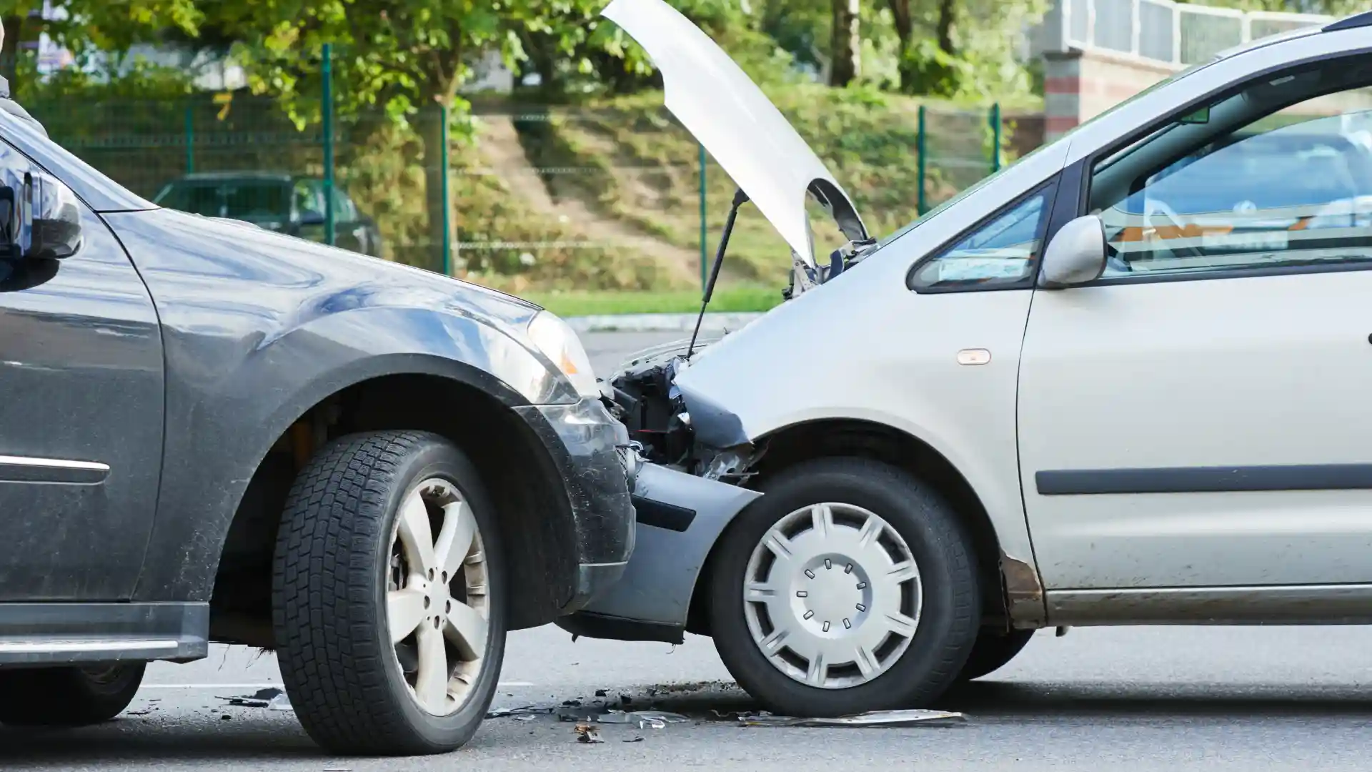 A rear-end car collision with visible damage and an open hood.