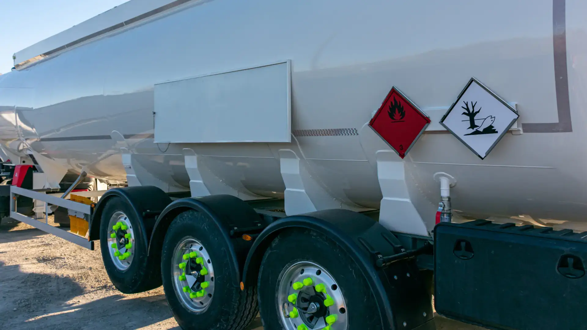 Close-up of a chemical tank truck with hazard warning signs on the side
