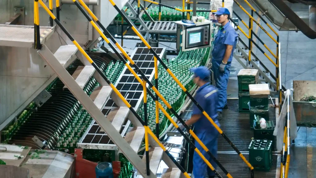 Workers operating machinery on a production line in a factory.